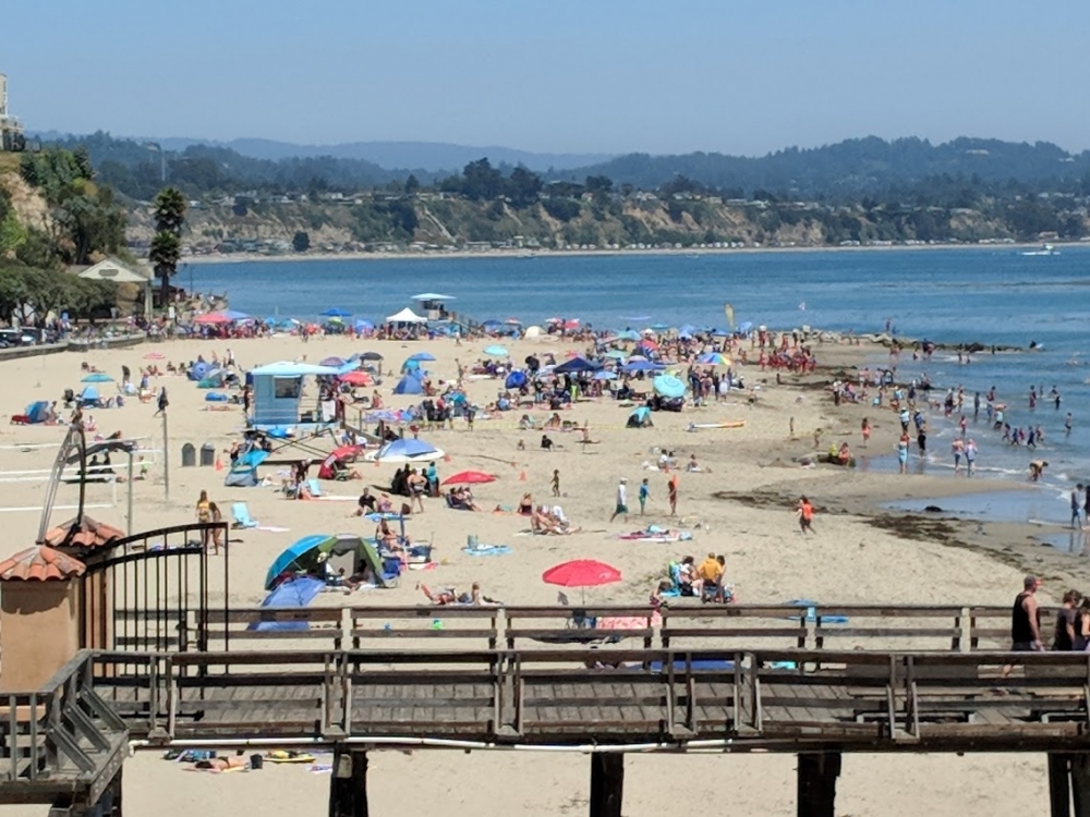 People gather to enjoy the surf at Capitola Beach.